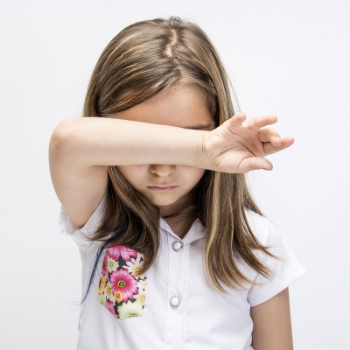 young girl with arm covering her eyes
